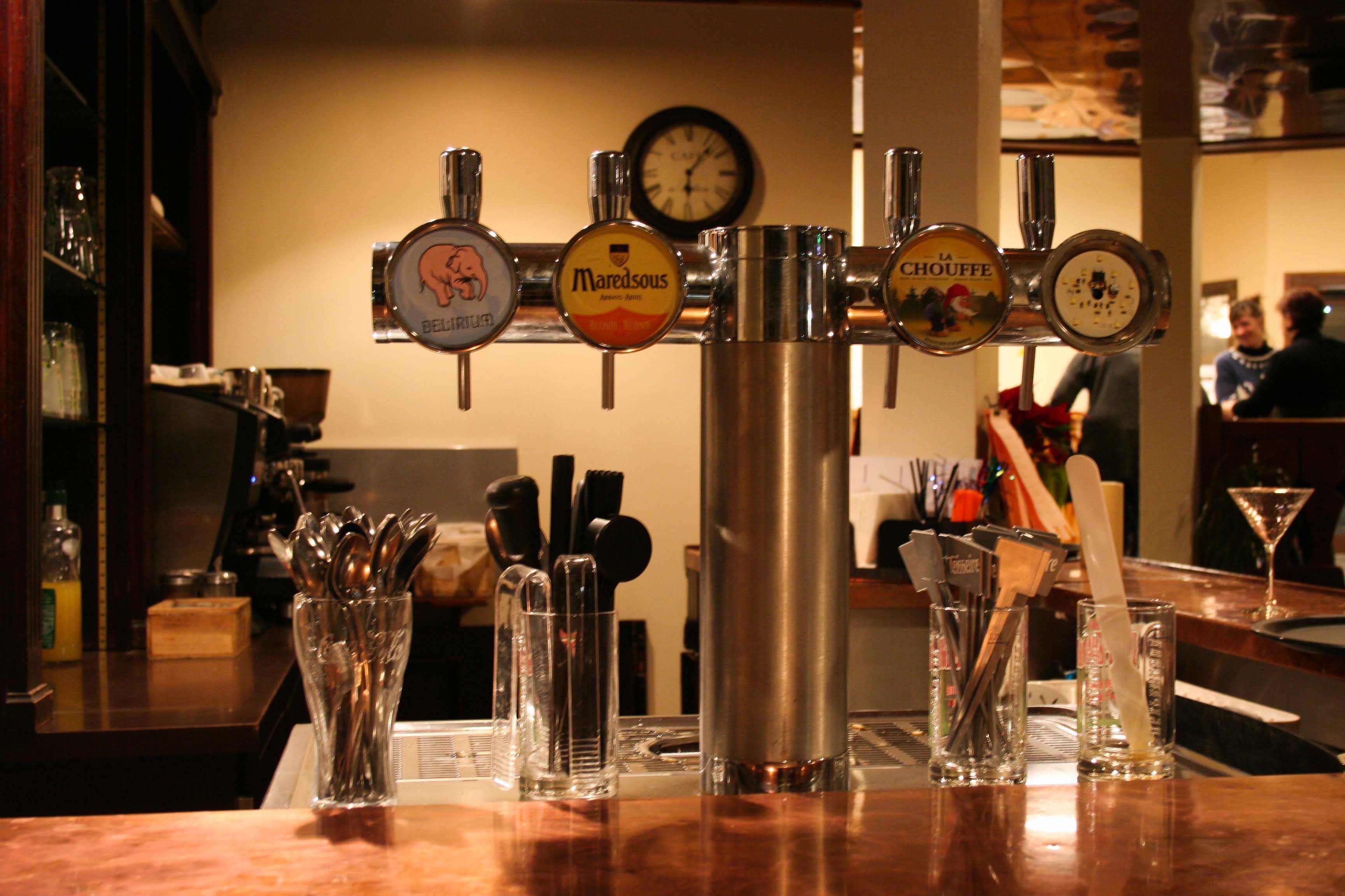 A bar with multiple taps, a clock, and various bar tools.