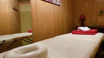 Relax in a serene space designed for massage and therapy, featuring a comfortable massage table and amenities.