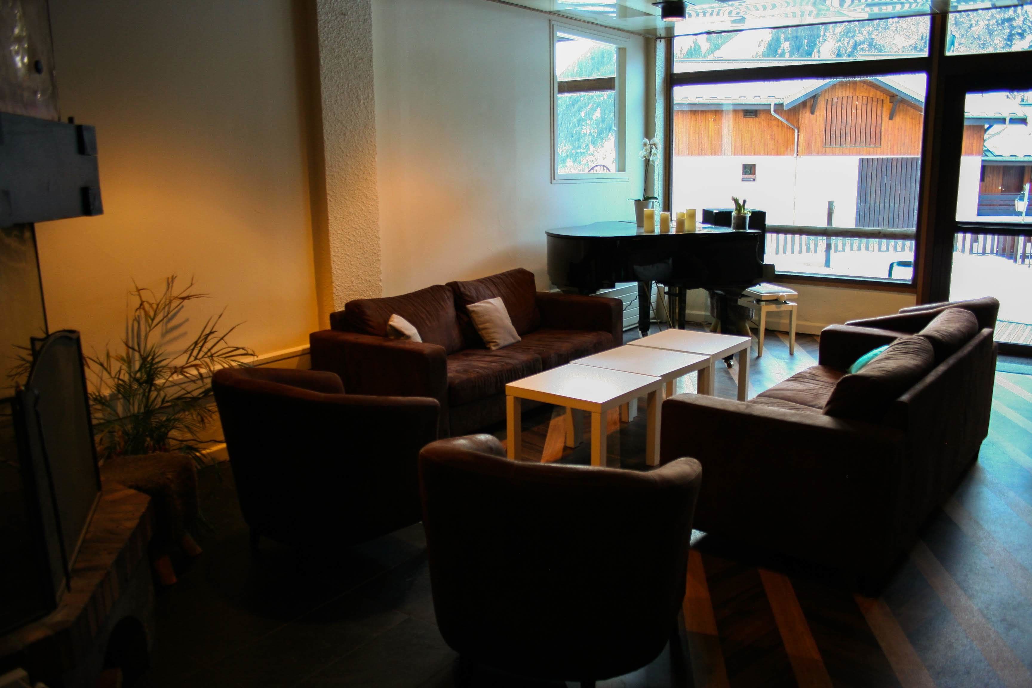 A cozy living room with a brown leather sofa, a wooden coffee table, and a TV on a stand.