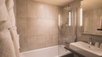 Une salle de bain moderne avec une douche à parois de verre, une baignoire blanche et un meuble-lavabo avec un évier et un miroir.