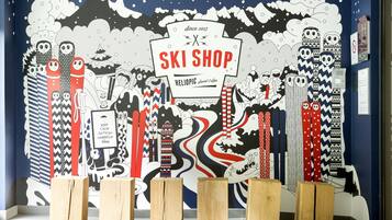 A wall with a ski shop sign and various ski equipment.