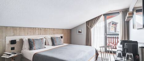 A hotel room with a large bed, a desk with a coffee maker, and a view of the outside.