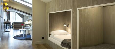 A modern hotel room with a loft bed, a desk, and a view of the city.