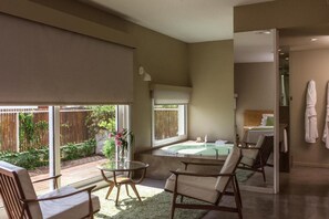 Un baño moderno con bañera, zona de ducha y ventana con cerramiento de vidrio.