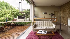 A modern living room with a sofa, coffee table, and bookshelves. - Home Hotel Buenos Aires (Buenos Aires)