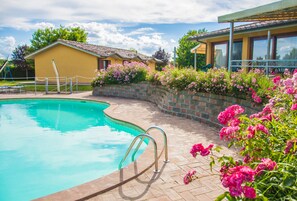 Una piscina al aire libre, sombrillas, tumbonas