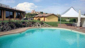 Piscine extérieure, parasols de plage, chaises longues