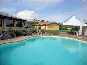 Una piscina al aire libre, sombrillas, tumbonas