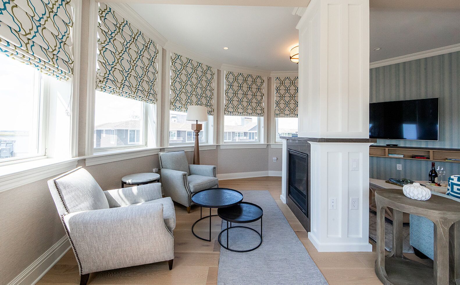 A living room with a fireplace, a TV, and a seating area with a round table and chairs.