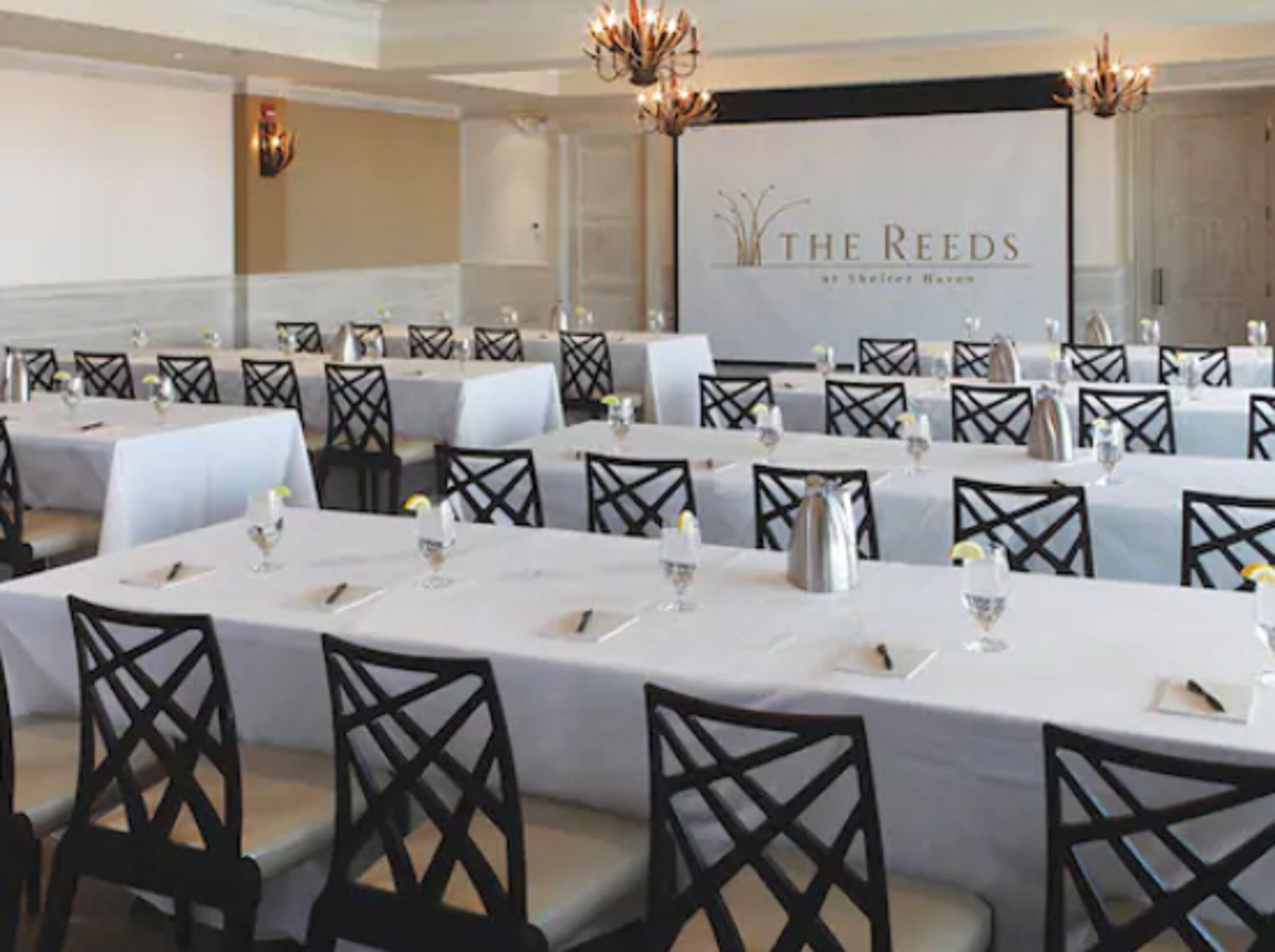 Un salón de conferencias en The Reeds con mesas dispuestas para una reunión.