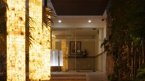 The entrance of Hotel Nader Suites with a modern design, featuring a prominent sign, a pathway leading to the entrance, and decorative pillars. - Hotel & Suites Nader (Cancun)