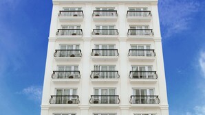 Un hotel de diversos pisos amb balcons i un rètol que diu 'Golden Sand Hotel'.