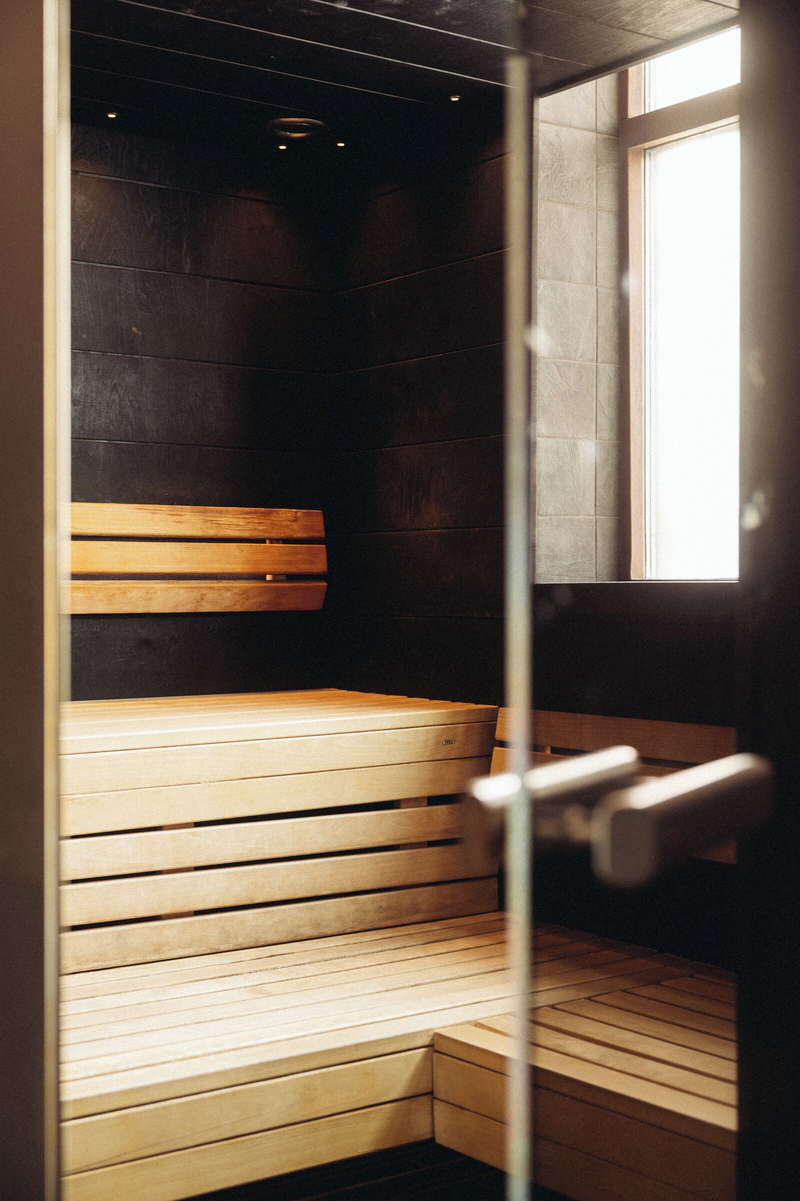 A sauna with wooden benches and a window.