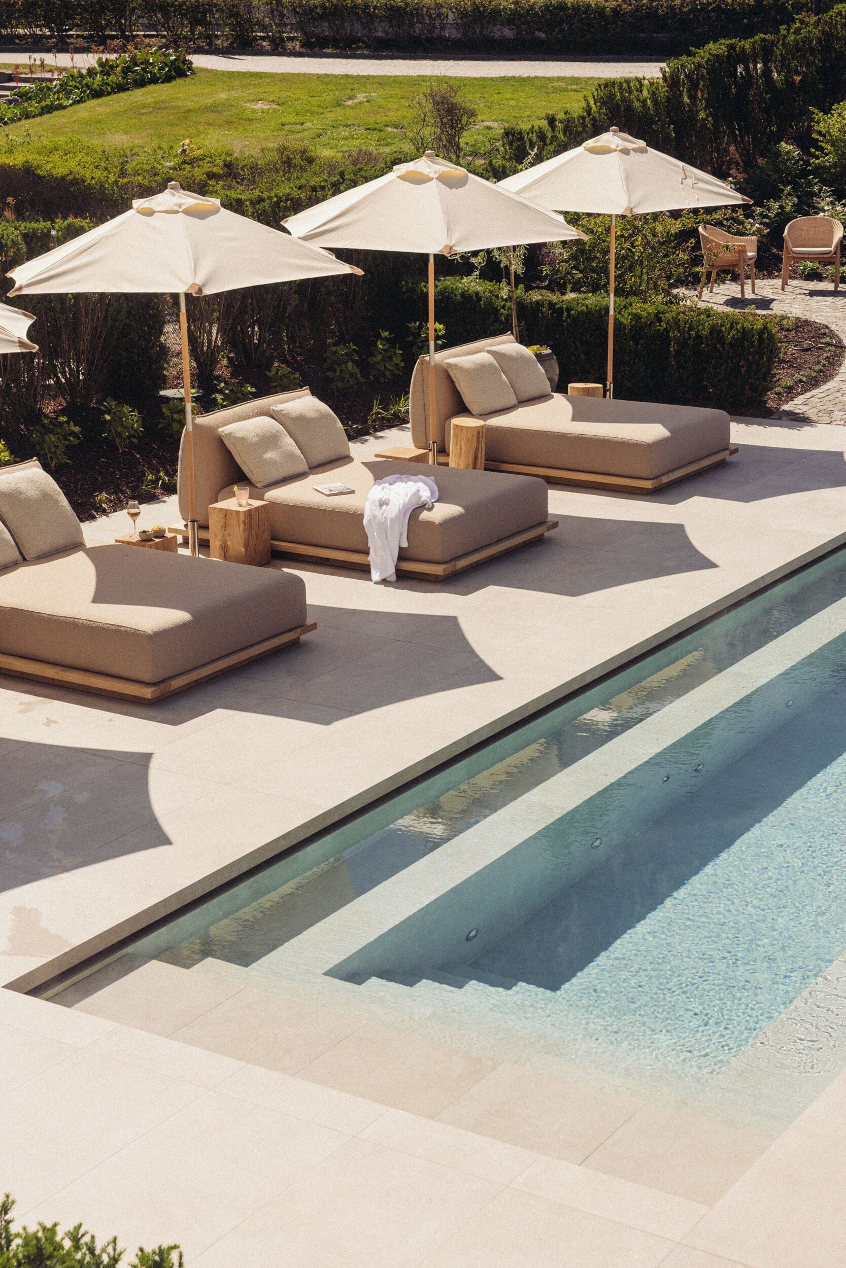 A poolside area with lounge chairs and umbrellas.