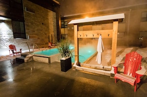 Un área de spa con un jacuzzi, un banco de madera y una silla roja.