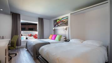 A hotel room with two beds, a desk, a chair, and a view of the pool.