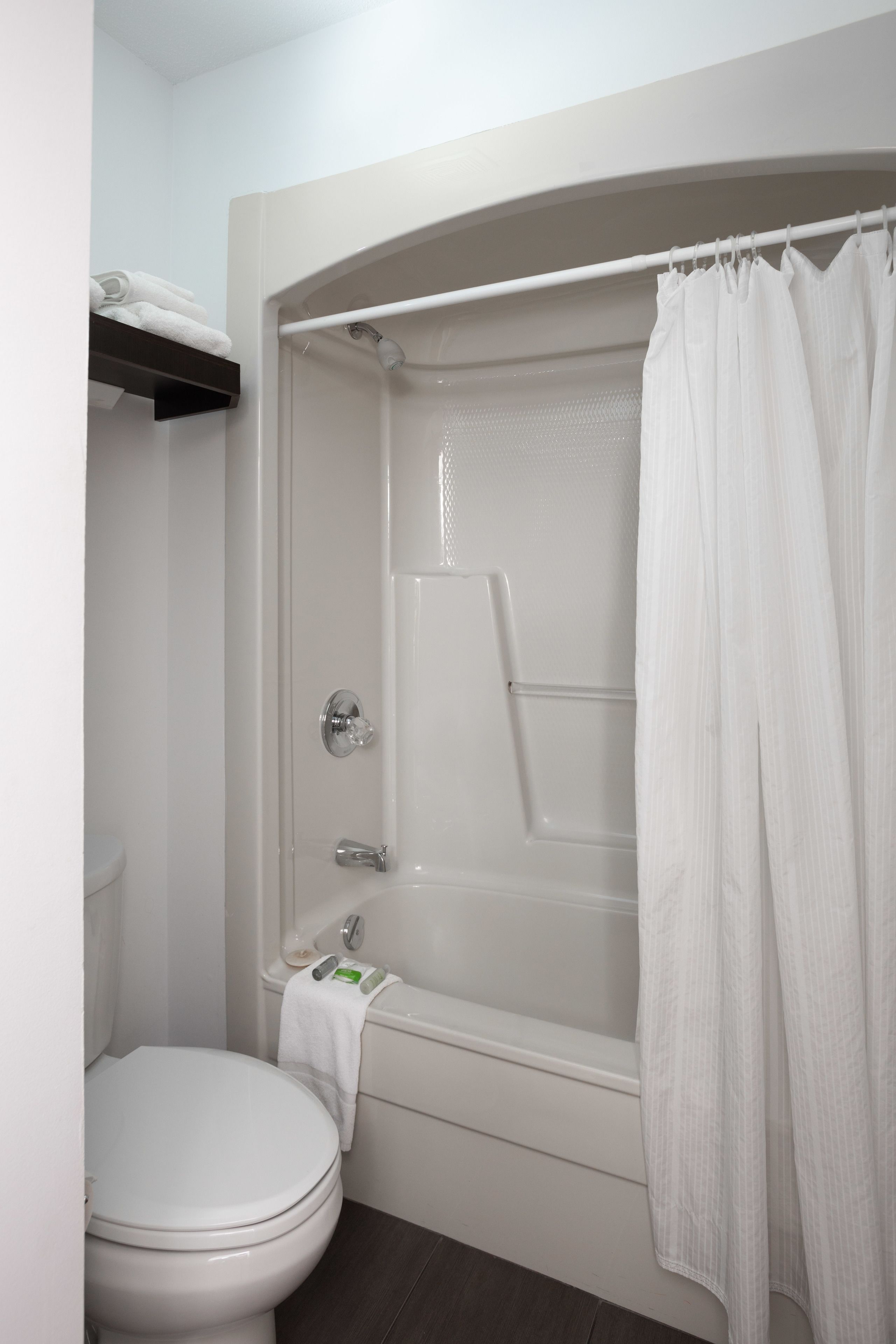 Un bagno con una vasca da bagno bianca, una doccia e un water.