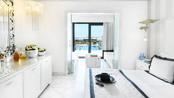 A hotel room with a bed, a bedside table, a dresser, a large mirror, and a view of a pool and balcony.
