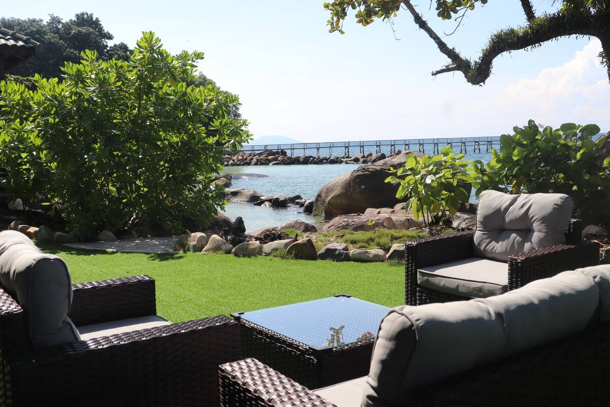 Outdoor seating with a view of a body of water and a bridge.