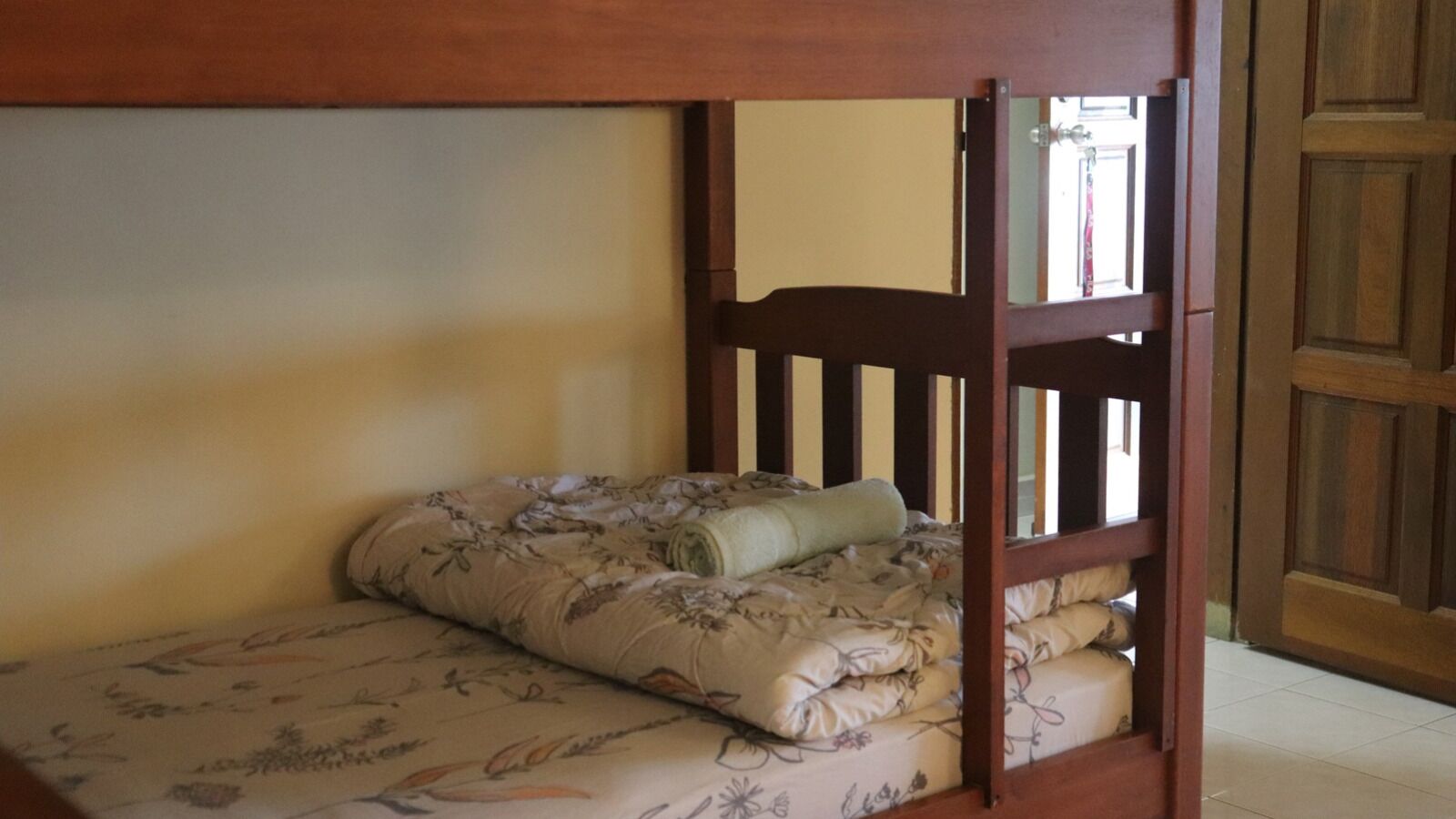 A bunk bed with floral bedding and a wooden headboard.
