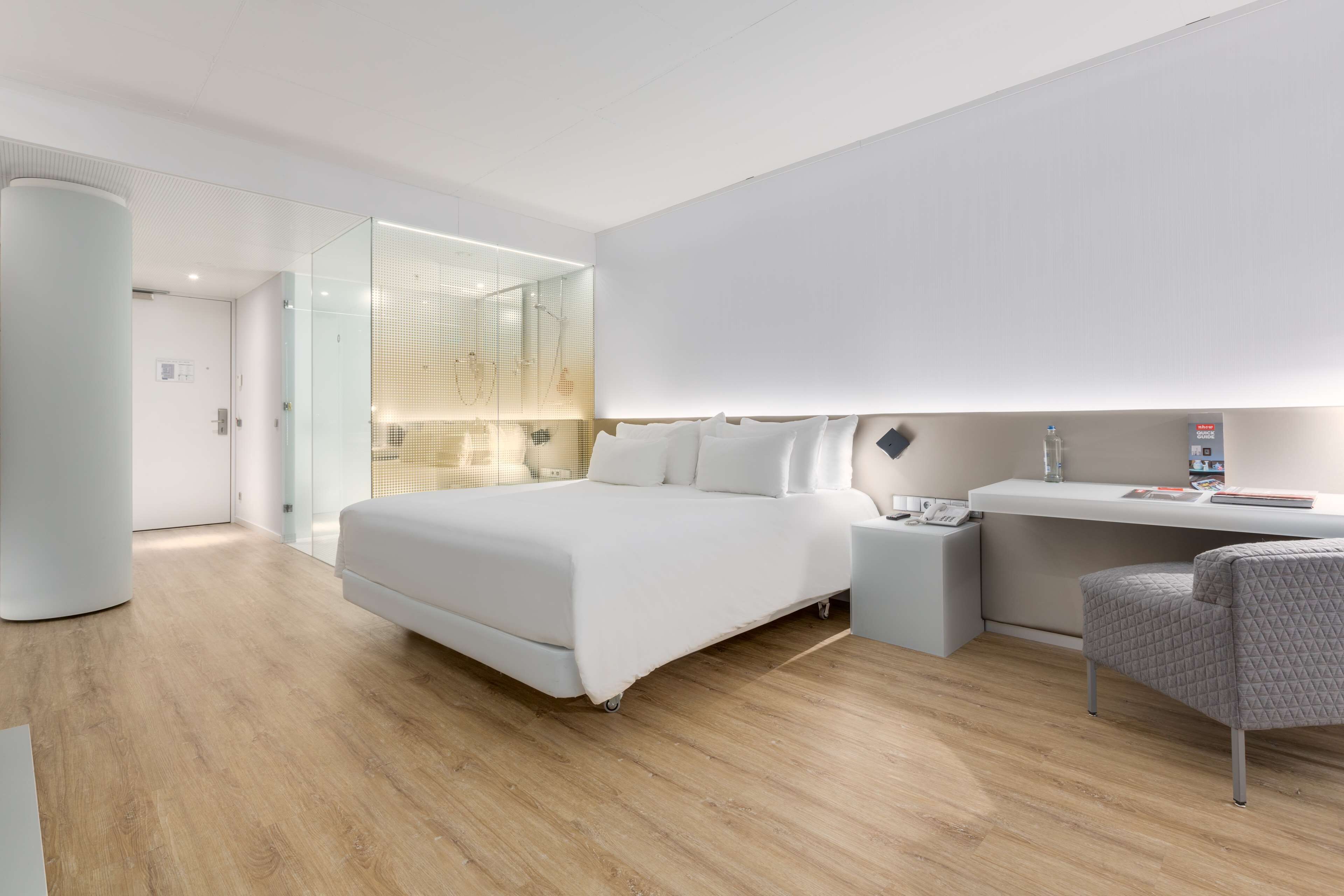 Una habitación de hotel moderna con una cama grande, un escritorio y una silla.