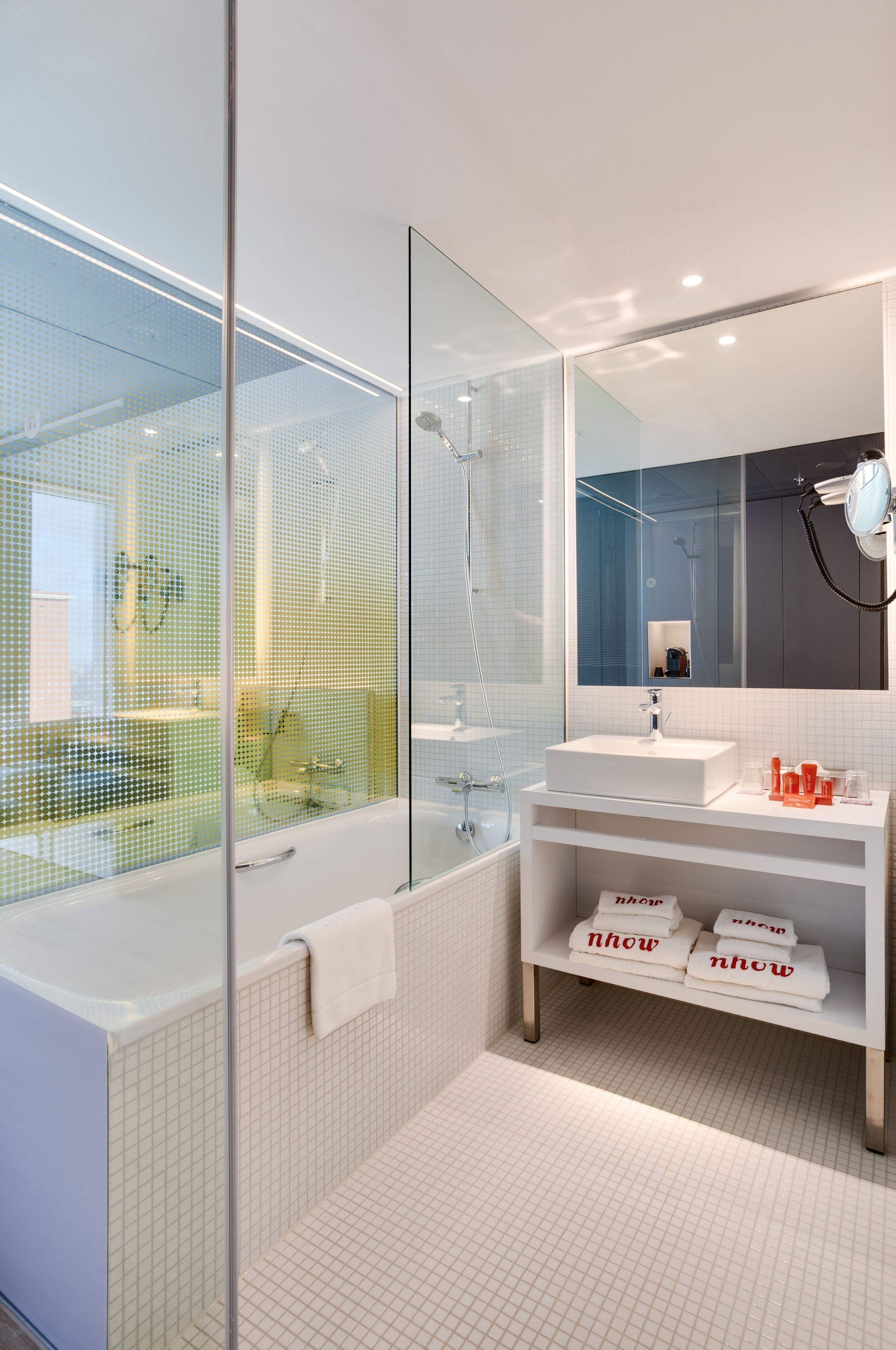 Une salle de bain moderne avec une douche à parois de verre, un lavabo blanc et un miroir au-dessus.