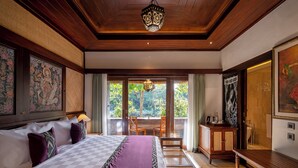 Un dormitorio espacioso con una cama grande, techo de madera y vistas al exterior a través de amplios ventanales.
