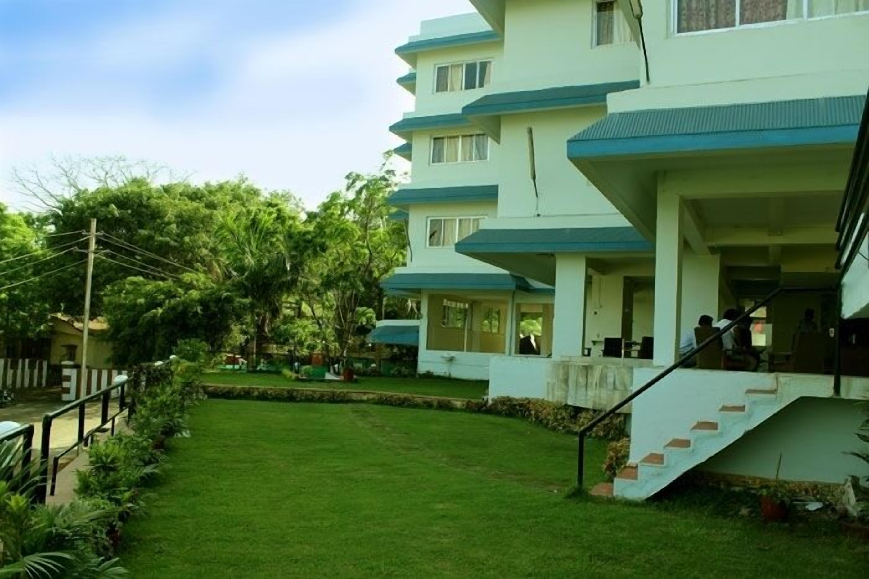 A multi-story building with a flat roof and a staircase leading to the entrance.