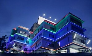 A multi-story residential building with modern architecture and colorful exterior lighting. - Sunrise Hill Resort (Mawal)