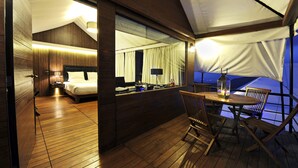 A cozy room with a bed, a desk, and a view through a window. - Della Resorts (Mawal)