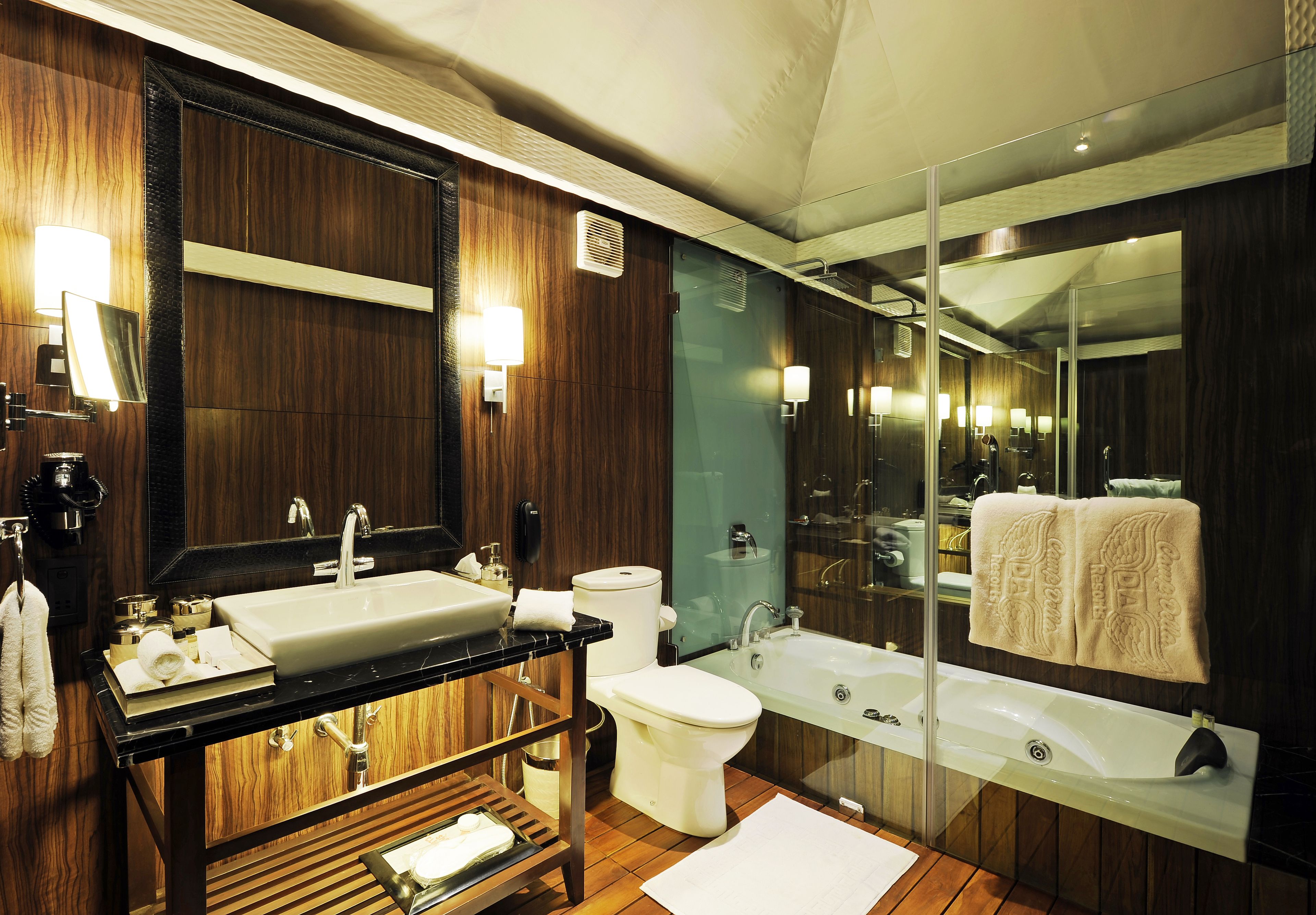 Un baño moderno con un espejo grande, lavamanos dobles, inodoro y bañera.