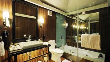 Un baño moderno con un espejo grande, lavamanos dobles, inodoro y bañera.