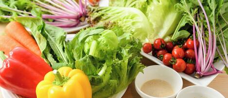 A variety of fresh vegetables including lettuce, tomatoes, and bell peppers on a plate.