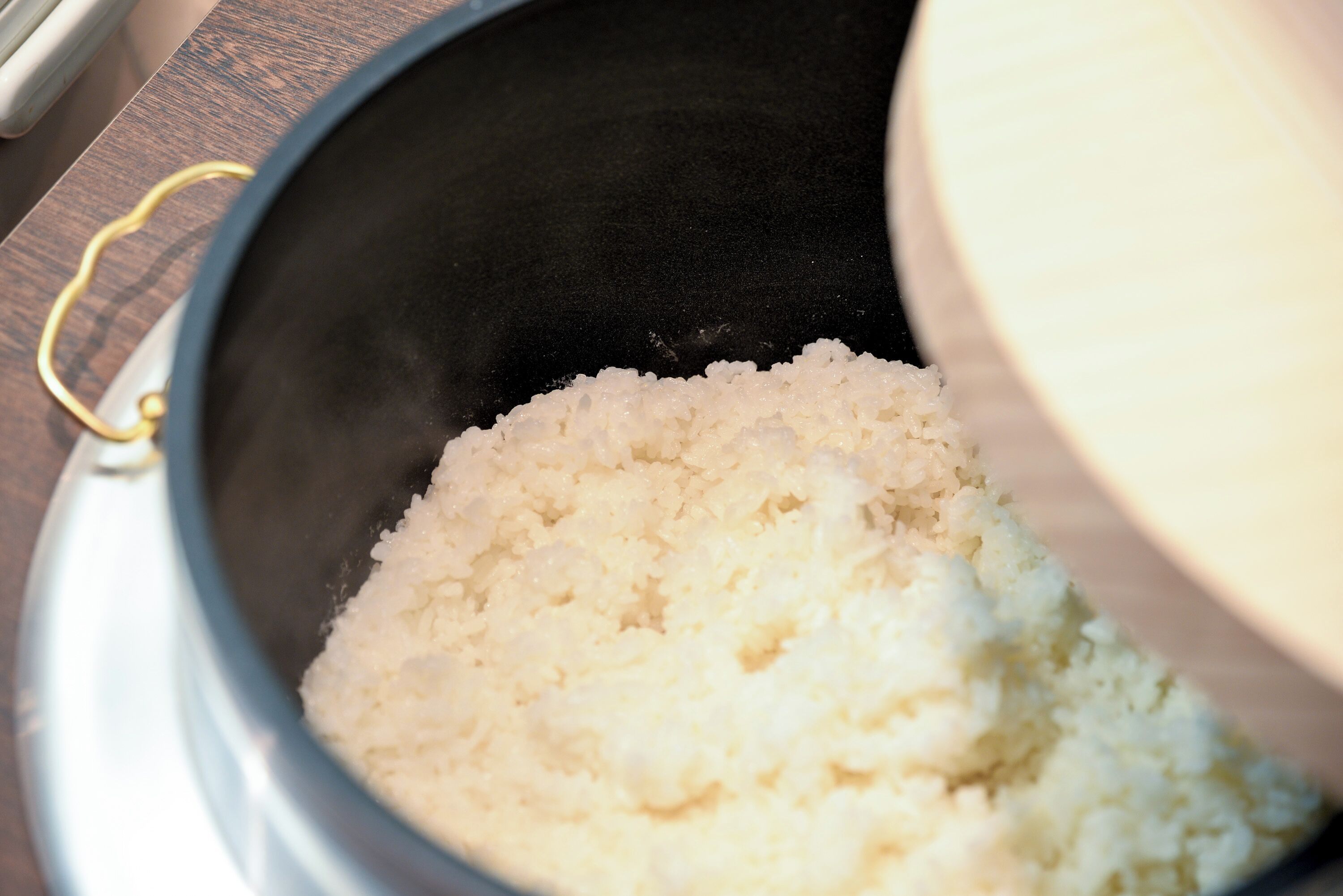 Una olla con asa que contiene arroz cocido.