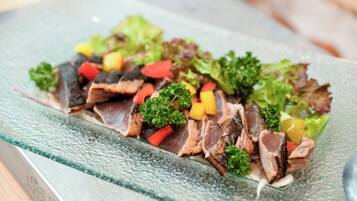 A glass plate with sliced meat and vegetables.