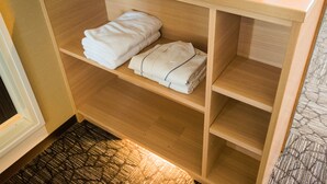 Ein Holzschrank mit Regalen, auf denen gefaltete Handtücher liegen.