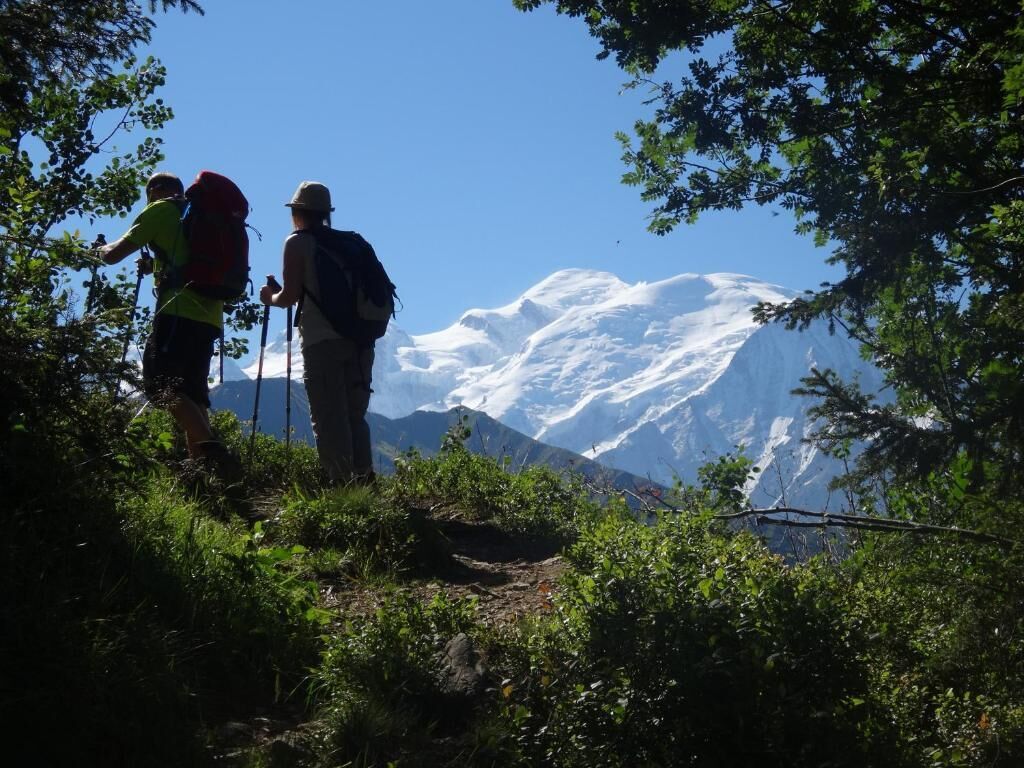 Twee wandelaars op een pad, met een berg op de achtergrond.