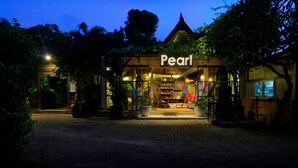 A building named 'Pearl' with a traditional architectural style, surrounded by greenery and a paved entrance. - Pearl Boutique Hotel - Adult Only (Legian)