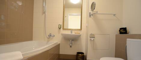 Une salle de bain avec une baignoire, un lavabo, des toilettes et un miroir.