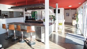 Une cuisine moderne avec un îlot central, des tabourets de bar et un plafond rouge.