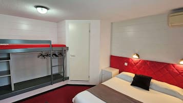 A bedroom with a bunk bed, a wardrobe, a bedside table, and a red headboard.