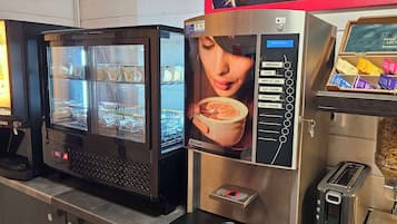 Una cafetera con pantalla digital y variedad de cápsulas de café.