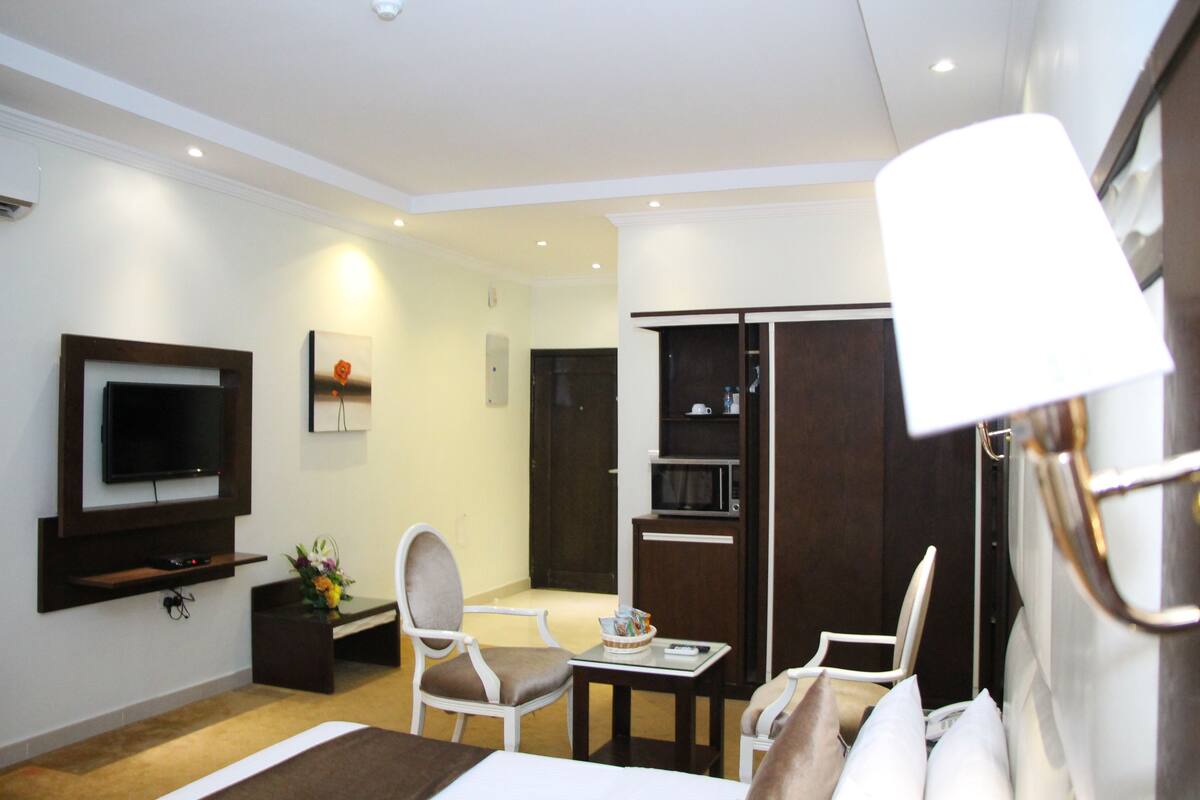 Une chambre d’hôtel équipée d’un lit, d’une télévision, d’un bureau et d’une armoire.