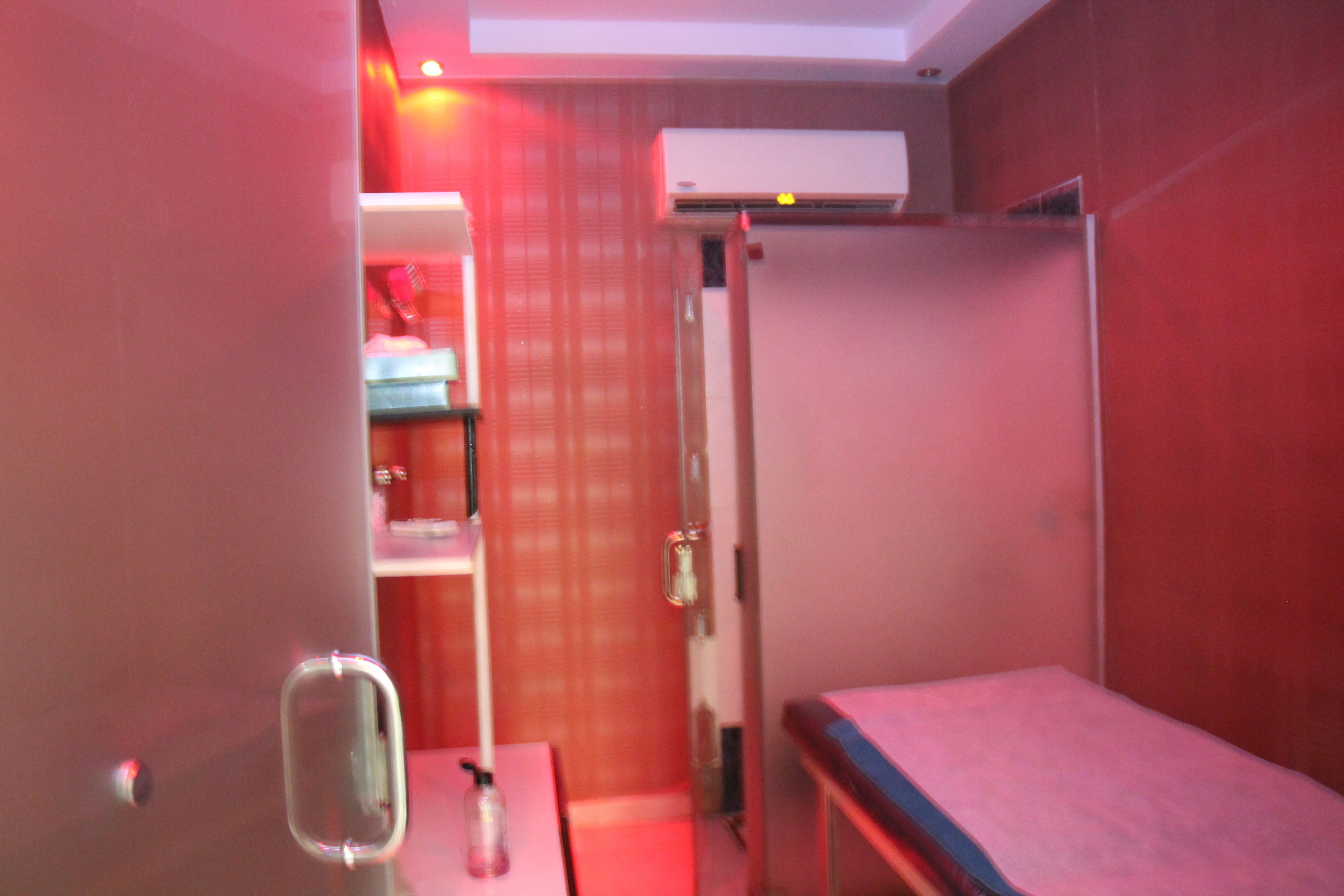 Habitación pequeña y acogedora con cama, espejo y repisas con artículos de aseo.