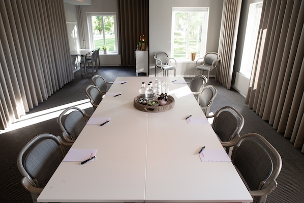 A conference room with a long table, chairs, and a buffet tray.