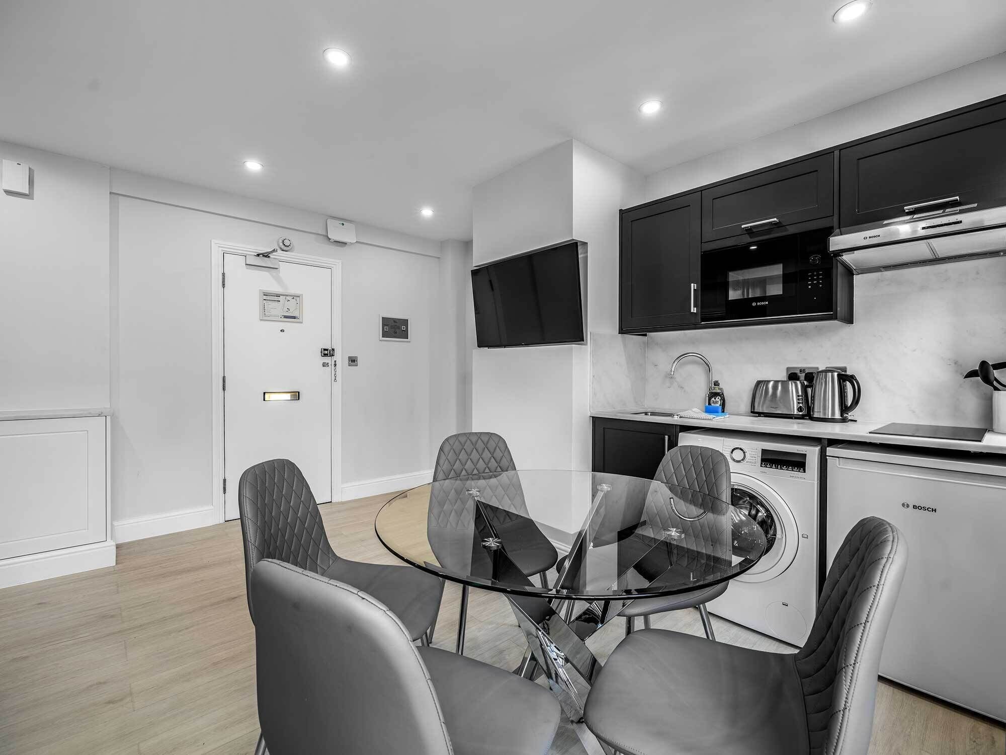 A compact kitchen with a microwave, toaster, and Bosch washing machine.