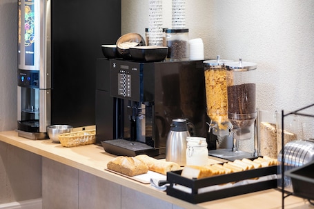 A coffee station with a coffee machine, coffee pots, and various coffee beans.