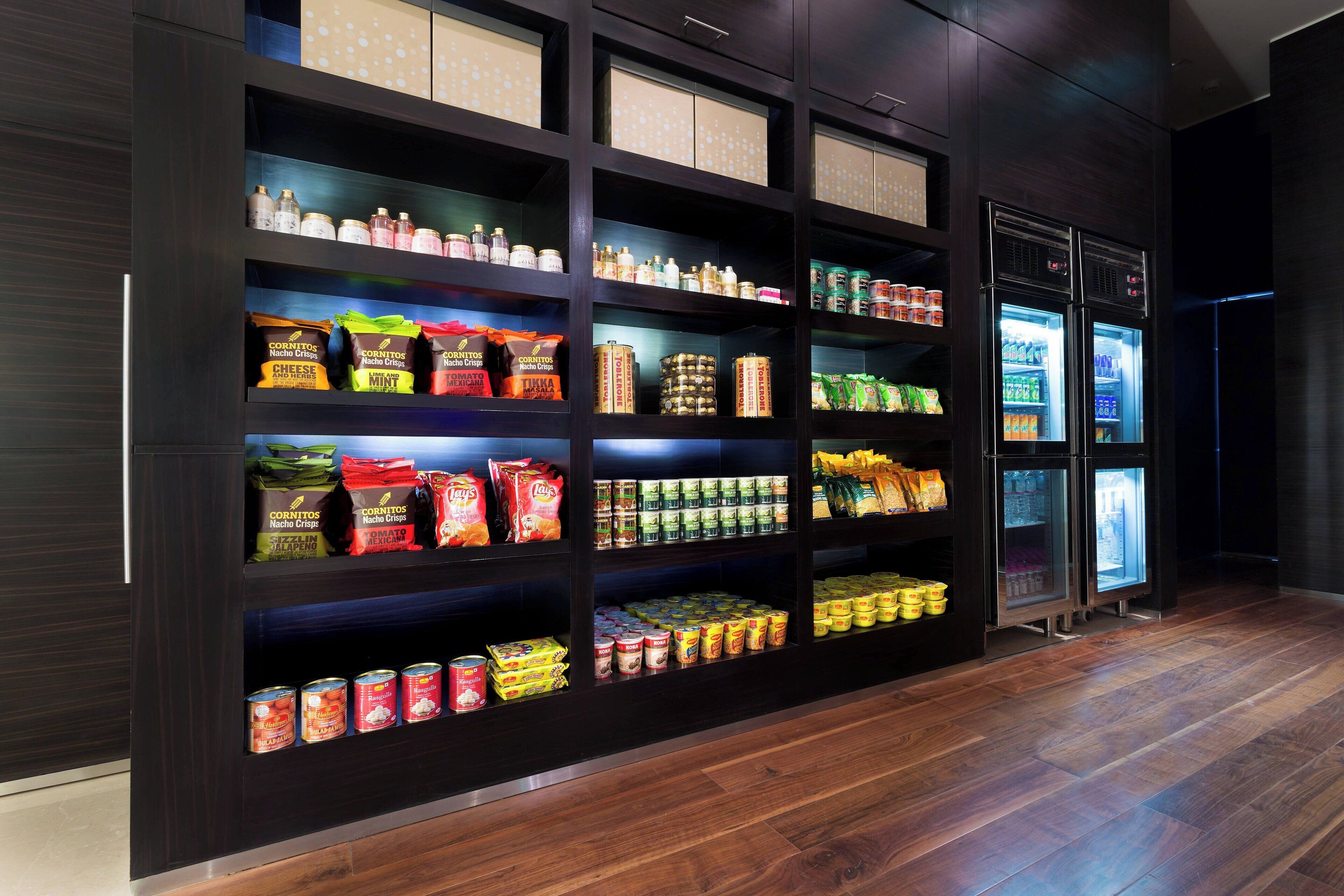 A well-organized pantry with various food items and a refrigerator.
