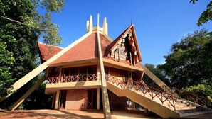 A building with a red roof, a balcony, and a staircase leading to the entrance. - Sanctum Spring (Varkala)
