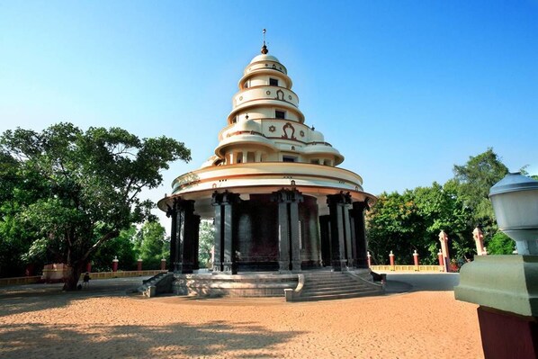 Um templo com vários níveis e uma cúpula central, rodeado por um espaço pavimentado com escadas de acesso.